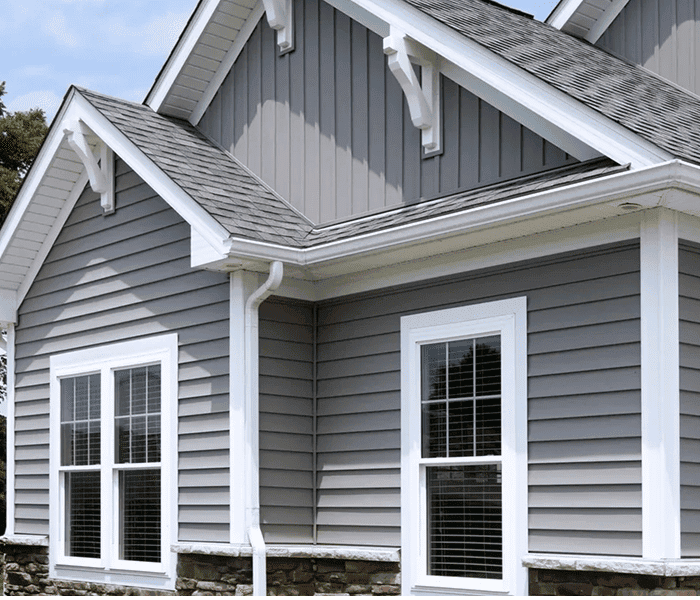 New gray vinyl siding on house with white trim and windows.