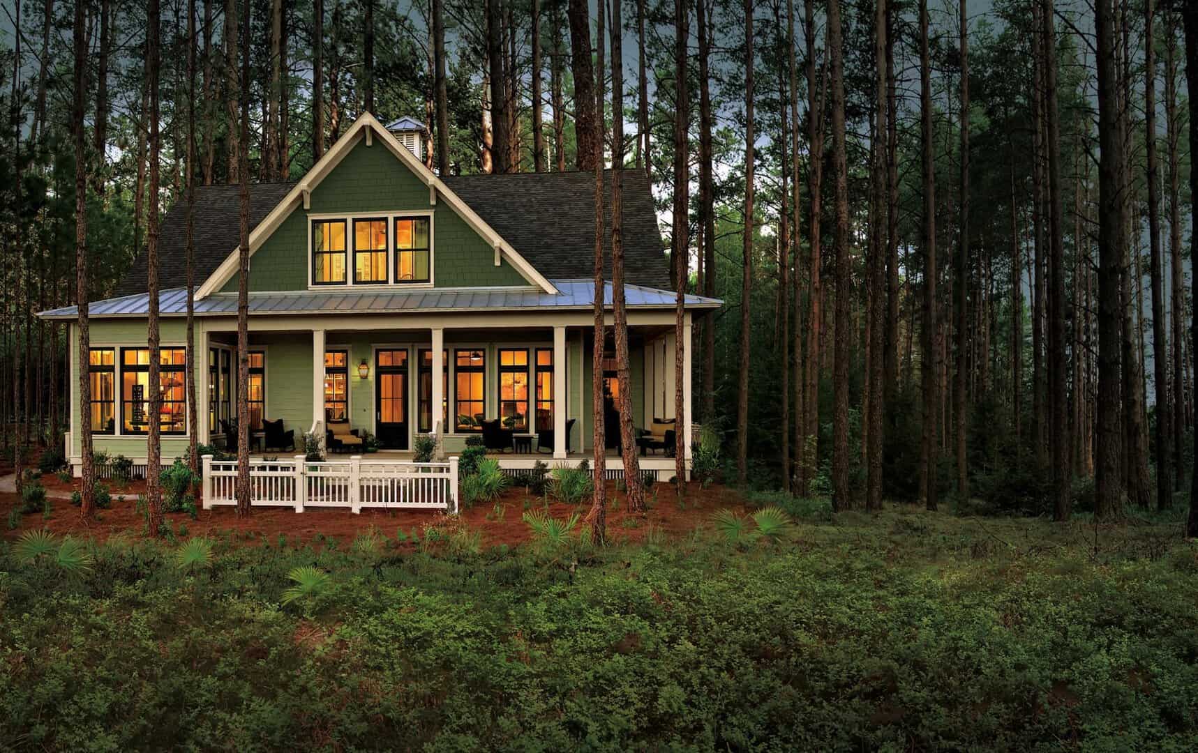Beautiful modern house with large porch surrounded by tall pine trees, showcasing expert constructio.
