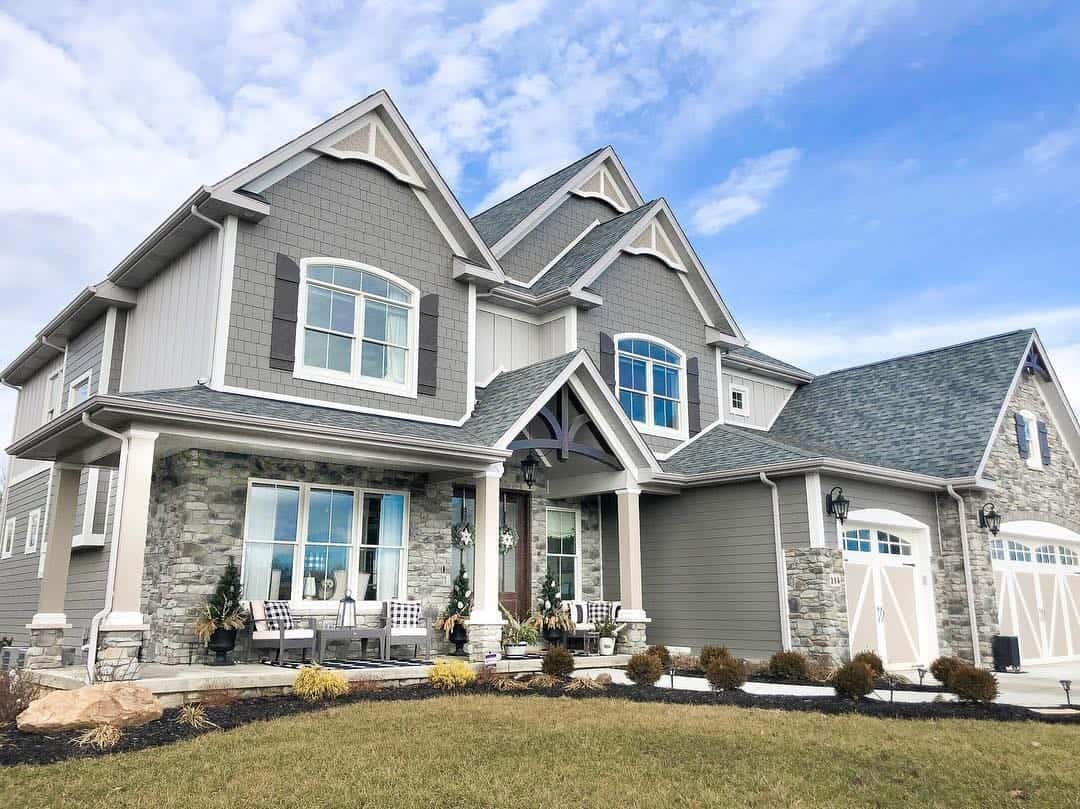 Beautiful modern house with new siding and stone accents, under a blue sky.